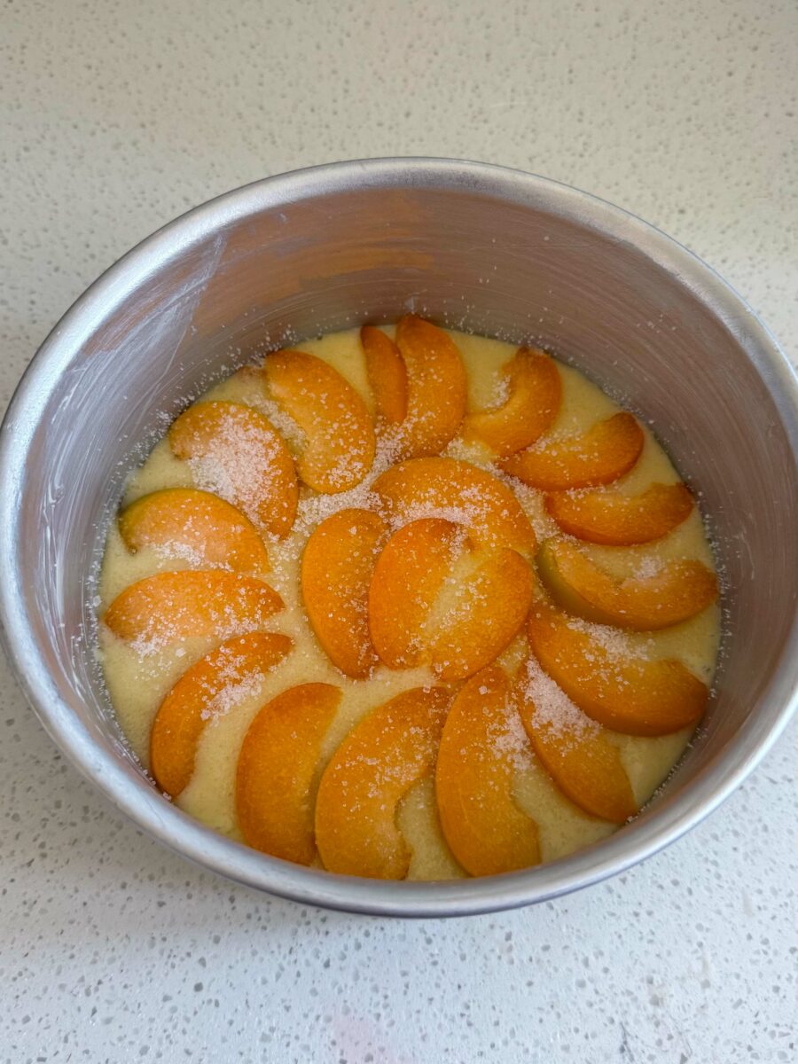 Recouvrez avec le reste de pâte, puis ajoutez quelques lamelles d’abricots sur le dessus…