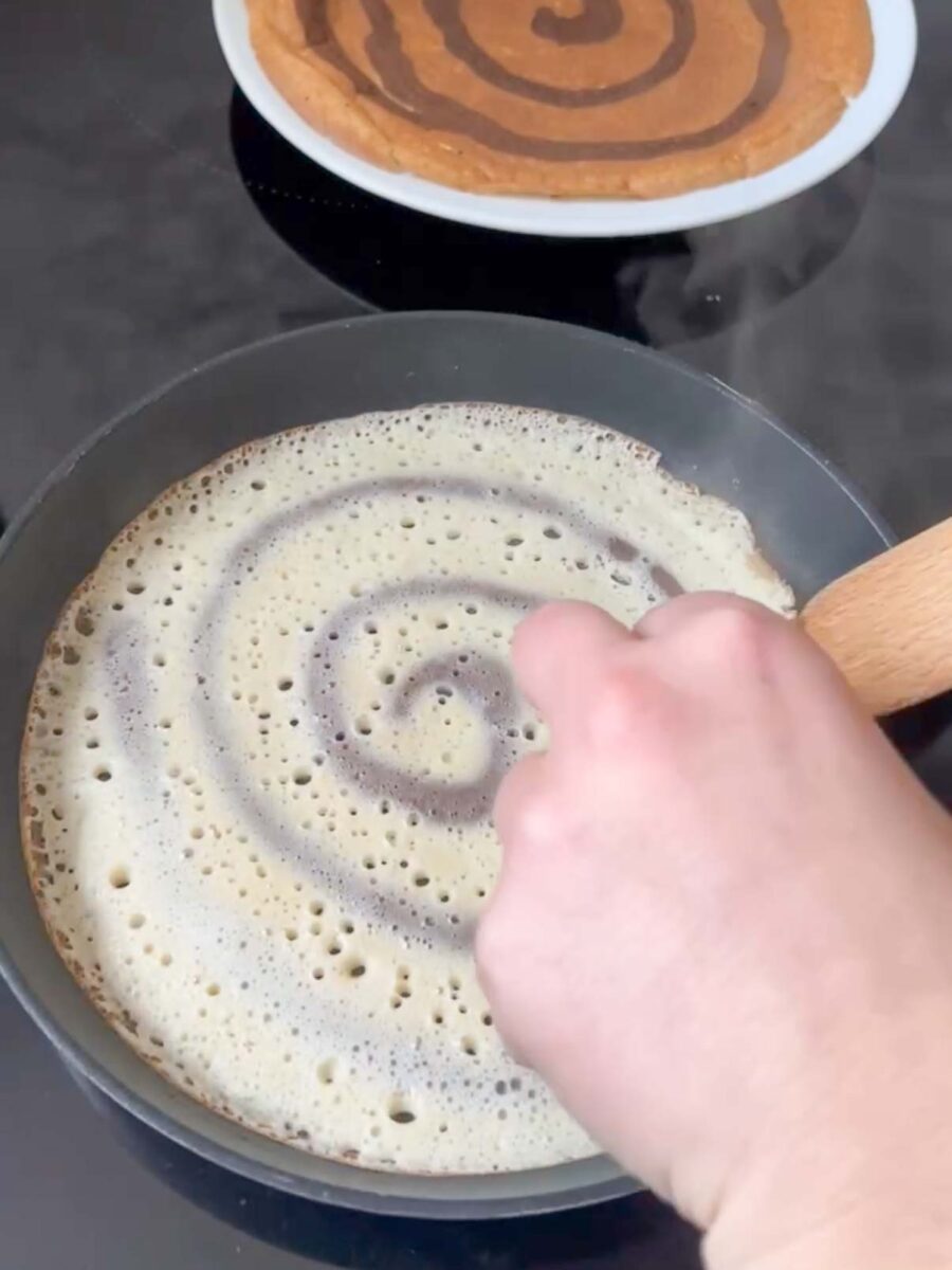 Versez ensuite la pâte nature dans la poêle pour former des crêpes tourbillon fines.
