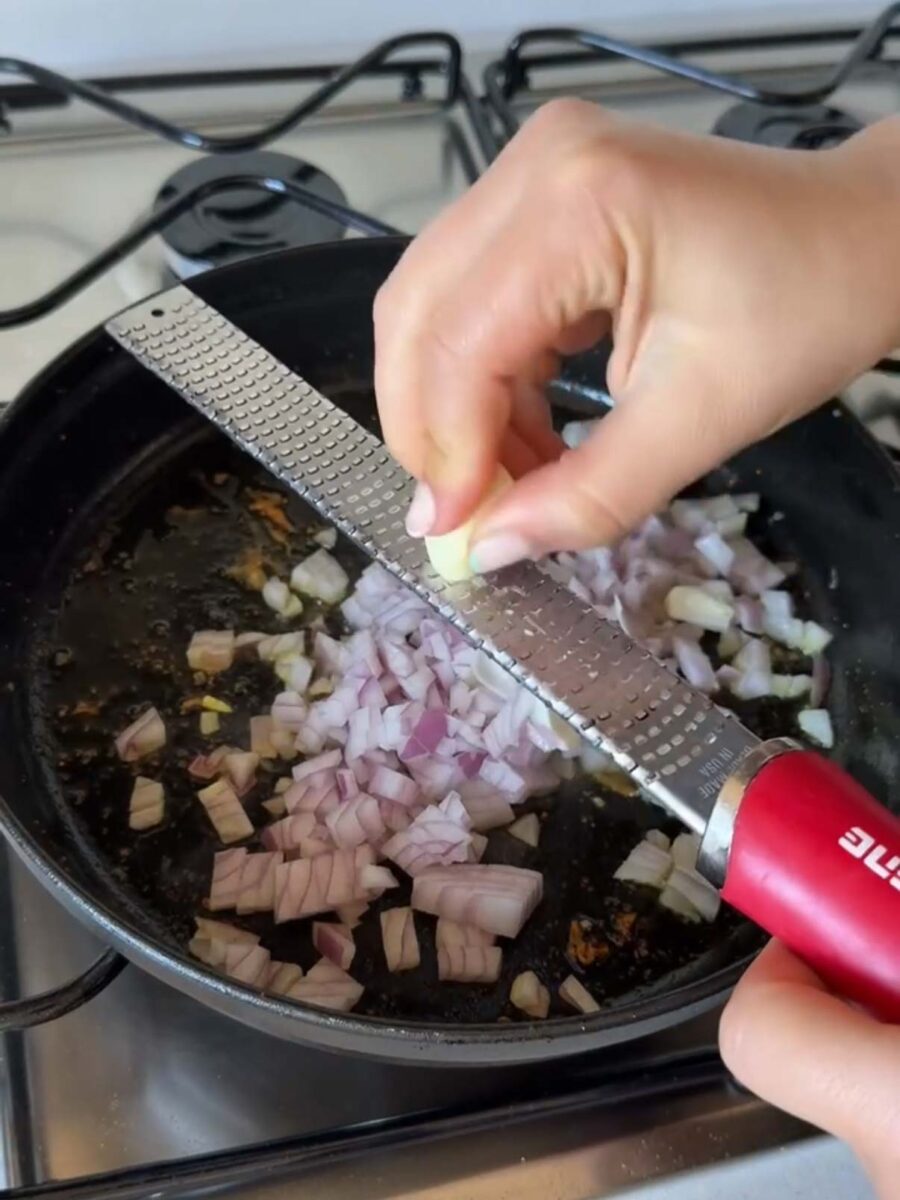 Faites ensuite revenir dans cette même poêle les oignons émincés et l’ail râpé.
